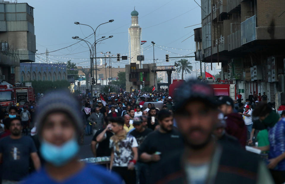 People walk through Khilani Square after protesters took control and reopened it, after clashes between Iraqi security forces and anti-government demonstrators in Baghdad, Iraq, Saturday, Nov. 16, 2019. (AP Photo/Hadi Mizban)