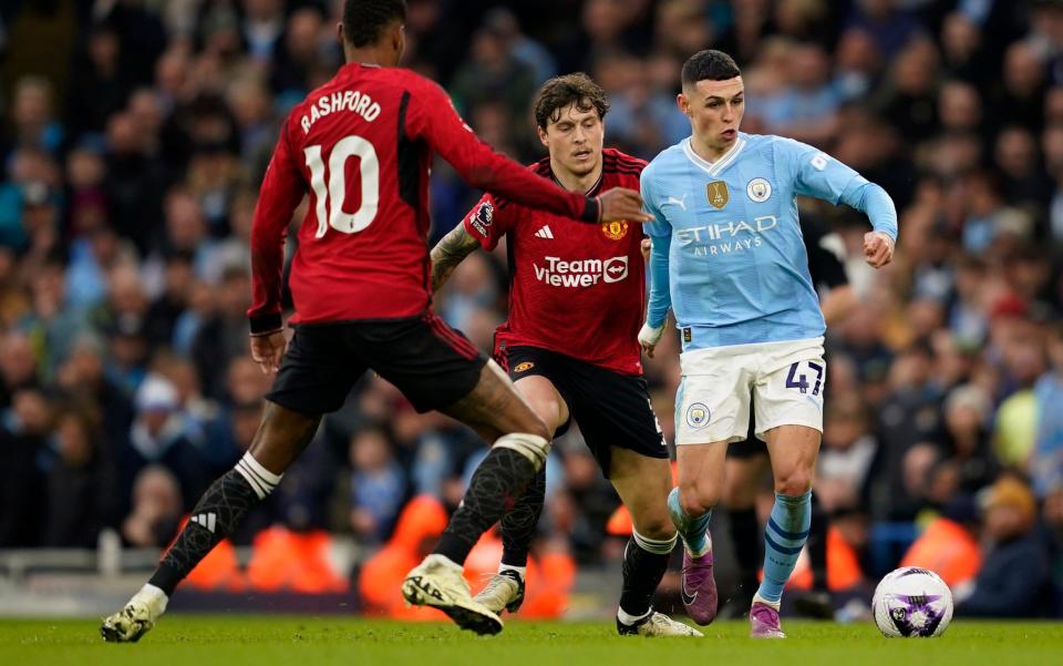 Victor Lindelof tries to get the ball off Phil Foden