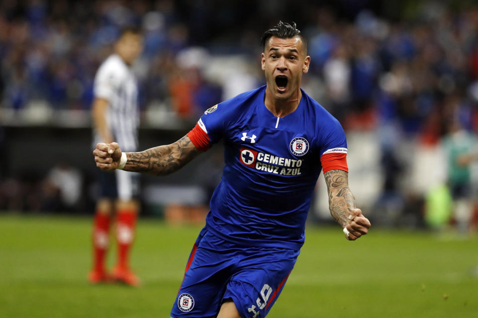 Cruz Azul's Milton Caraglio celebrates his goal against Monterrey's Cesar Montes, background, during a Mexico soccer league second leg semifinals match at Azteca stadium in Mexico City, Saturday, Dec. 8, 2018. (AP Photo/Moises Castillo)