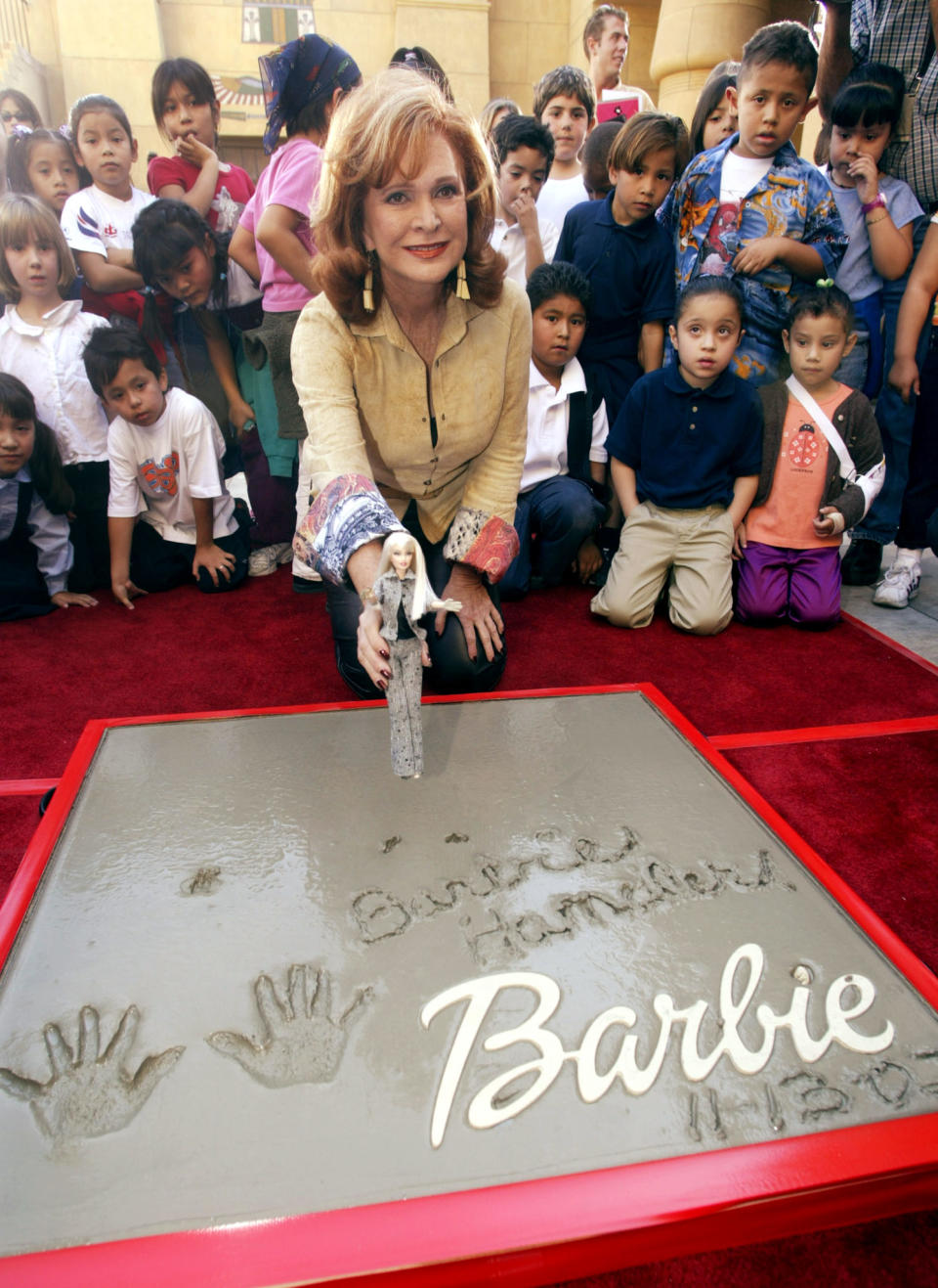 Barbara Handler, daughter of the creator of the Barbie doll, poses as
she holds a Barbie after placing the dolls hand and footprints in
cement during ceremonies November 13, 2002 in Hollywood at the Egyptian
Theatre. Local schoolchildren attended the ceremony. The doll debuted
in 1959 as a teen fashion model doll and has sold millions worldwide.
REUTERS/Fred Prouser

FSP