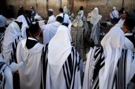 <p>Jewish men pray with a Torah scroll at the Western Wall in the Old City of Jerusalem on the eve of Yom Kippur also known as the Day of Atonement, the holiest day of the year in Judaism, on Sept. 28, 2017. (Photo: Thomas Coex/AFP/Getty Images) </p>