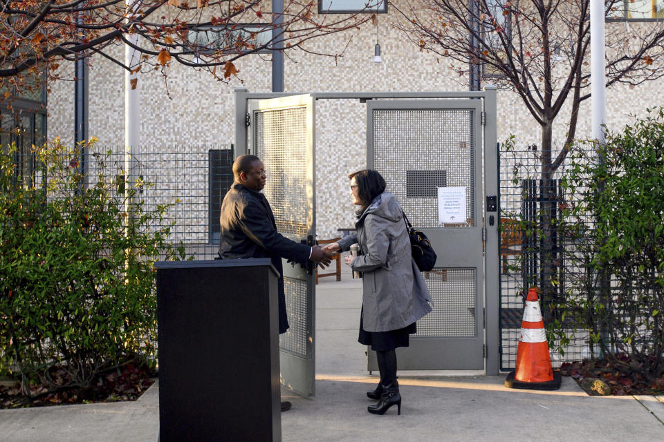 In this Saturday, Feb. 1, 2020, photo, Rabbi Jacqueline Mates-Muchin greets security guard Max Baker as she arrives at Temple Sinai in Oakland, Calif. Her synagogue has beefed up security measures such as more lighting, security cameras and guards. For the most recent High Holy Days, synagogue leaders requested the deployment of armed off-duty police officers. (AP Photo/Noah Berger)