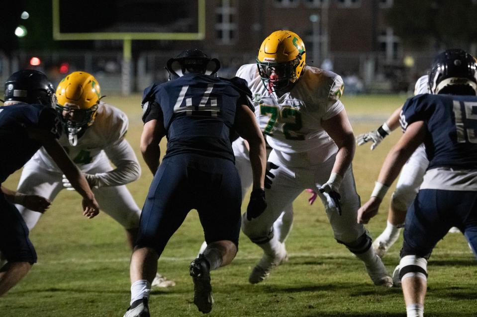 Ryland Bragg (72) engages the Braves defensive line as the Crusaders score a touchdown to take a 41-7 lead during the Catholic vs Walton high school playoff football game at Walton HIgh School in DeFuniak Springs on Friday, Nov. 17, 2023.