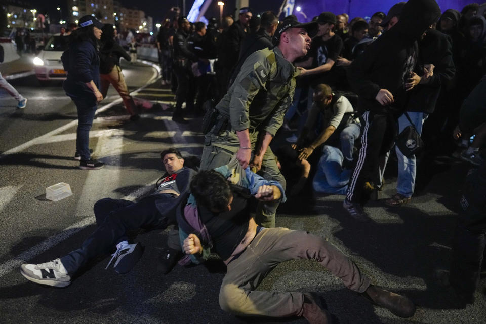 Police drag away people who take part in a protest against Israeli Prime Minister Benjamin Netanyahu's government and call for the release of hostages held in the Gaza Strip by the Hamas militant group outside of the Knesset, Israel's parliament, in Jerusalem, Sunday, March 31, 2024. Tens of thousands of Israelis gathered outside the parliament building in Jerusalem on Sunday, calling on the government to reach a deal to free dozens of hostages held by Hamas and to hold early elections. (AP Photo/Ohad Zwigenberg)