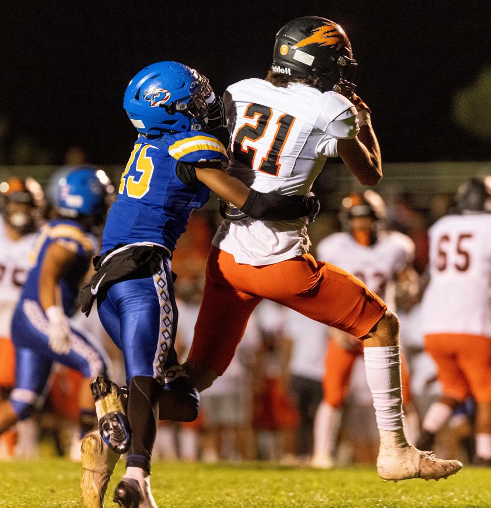 Apple Valley's Leonard Carrasco catches a pass while wrapped up by Serrano's Tamatoa Semaia  on Thursday, Sept. 29, 2022.  The Sun Devils won 50-0.