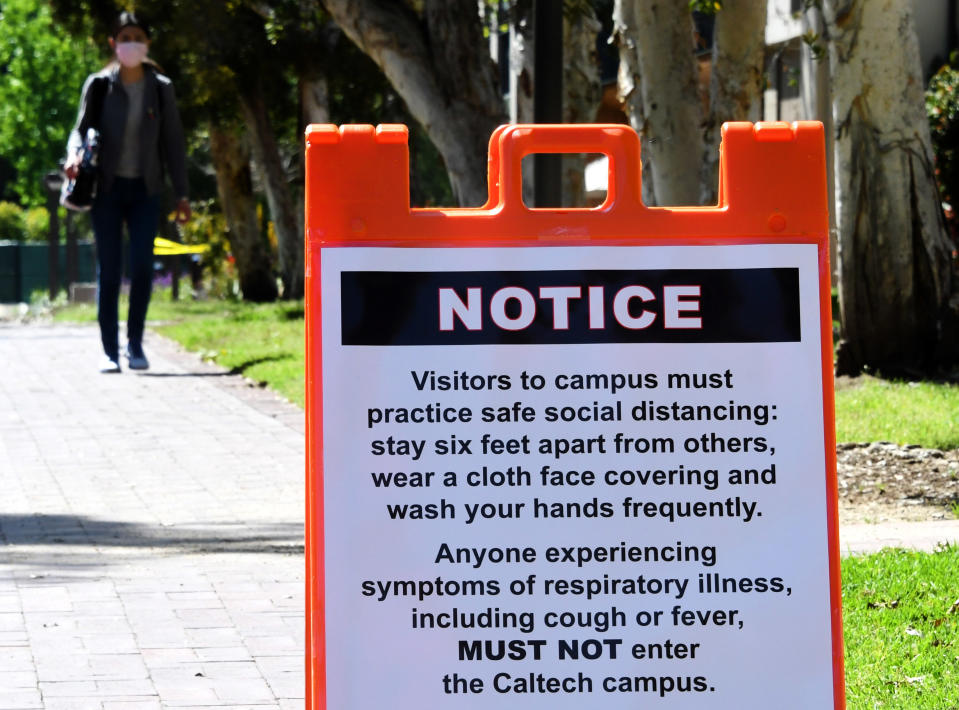 PASADENA, CA - APRIL 14:  A woman wearing a mask walks on the campus of Caltech that is closed due to the Coronavirus Pandemic in Pasadena on Tuesday, April 14, 2020. (Photo by Keith Birmingham/MediaNews Group/Pasadena Star-News via Getty Images)