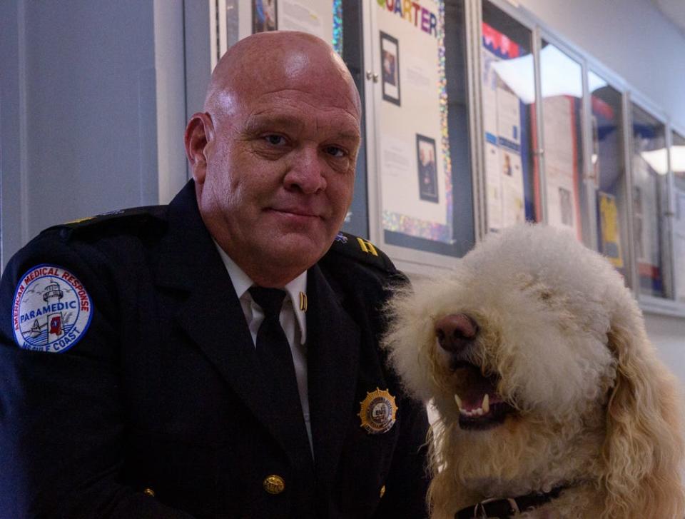Deputy Chief of Operations Charles Wise poses with Tucker, an in-house therapy dog, at the AMR South Mississippi office in Gulfport on Wednesday, Dec. 1, 2021.