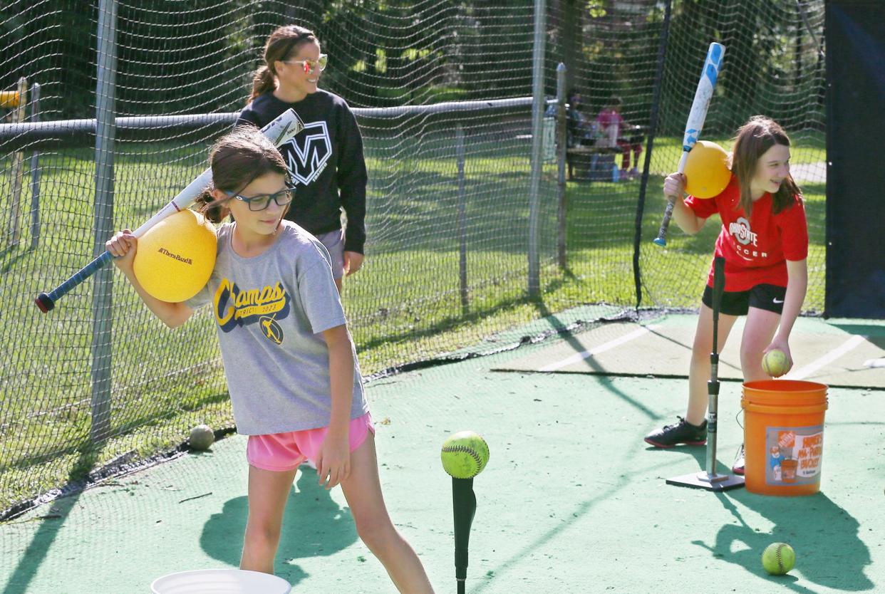 Tracee McCoy-Jenkins, an Ellet High School, University of Akron and Akron Racers softball legend, watches her students Lydia, 10, and Brynn, 12, as they work on skills in the batting cages at Stein Field at Indian Hills Park in Tallmadge on Aug. 22.