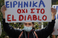 A protestor holds a banner reading in Greek " Peace, not to the El Diablo" , outside Cyprus' national broadcasting building, during a protest, in capital Nicosia, Cyprus, Saturday, March 6, 2021. The Orthodox Church of Cyprus is calling for the withdrawal of the country’s controversial entry into this year’s Eurovision song context titled “El Diablo”, charging that the song makes an international mockery of country’s moral foundations by advocating “our surrender to the devil and promoting his worship.” (AP Photo/Petros Karadjias)