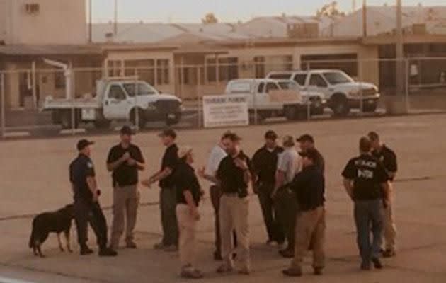 Officials and a sniffer dog waited on the tarmac. Source: MEGA