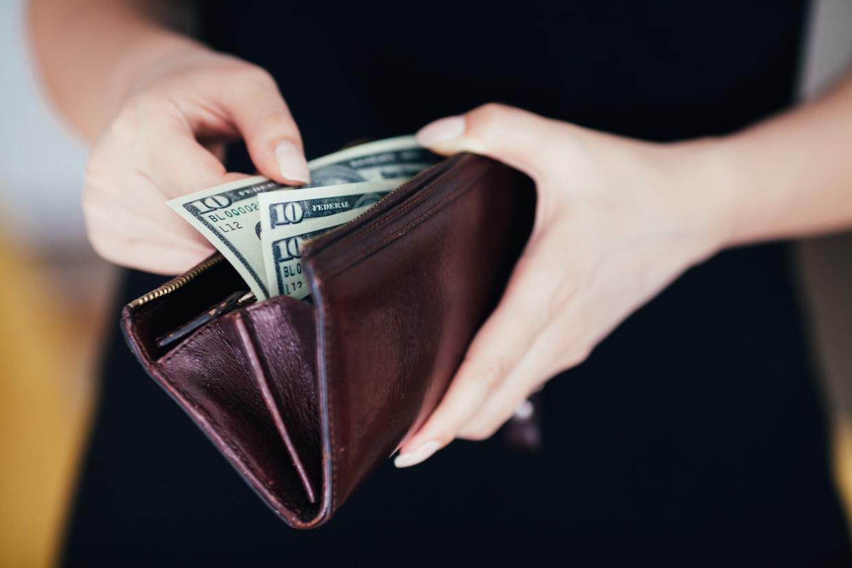 woman is taking out money from wallet