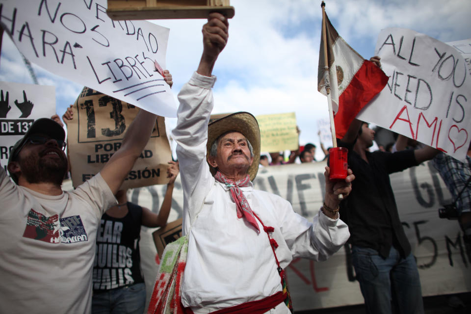 A man holds a Mexican flag during a demonstration to protest a possible return of the old ruling Institutional Revolutionary Party (PRI) and against what is perceived as a biased coverage by major Mexican TV networks directed in favor of PRI's candidate Enrique Pena Nieto in Mexico City, Wednesday, May 23, 2012. Mexico will hold presidential elections on July 1. (AP Photo/Alexandre Meneghini)