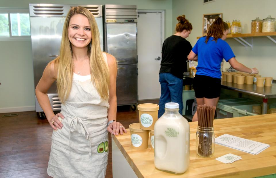 Bre Cross has moved her smoothie business, Real Smooth Foods, from the ghost kitchen in Vero Italiano restaurant in Junction City to a nearby vacant storefront at Suite 101A in the shopping center. Cross opened the business in January and attracted more customers than she expected, allowing her to move into her own place and expand her hours. She also now sells half-gallon jugs of the homemade almond milk she uses in her smoothies. Employees Gracy Bruer, right, and Mia Franciskovich fill containers with smoothie ingredients.