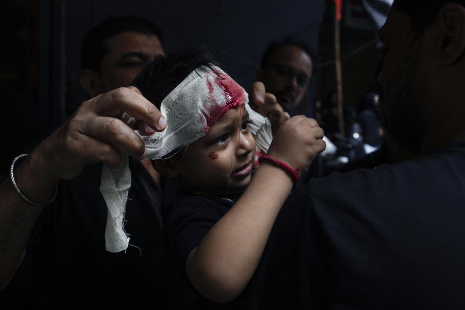 A bandage is put on the forehead of a young Shiite Muslim boy to contain bleeding during a procession to mark Ashoura in Hyderabad, India, Saturday, July 29, 2023. Ashoura is the tenth day of Muharram, the first month of the Islamic calendar, observed around the world in remembrance of the martyrdom of Imam Hussein, the grandson of Prophet Mohammed. (AP Photo/Mahesh Kumar A.)
