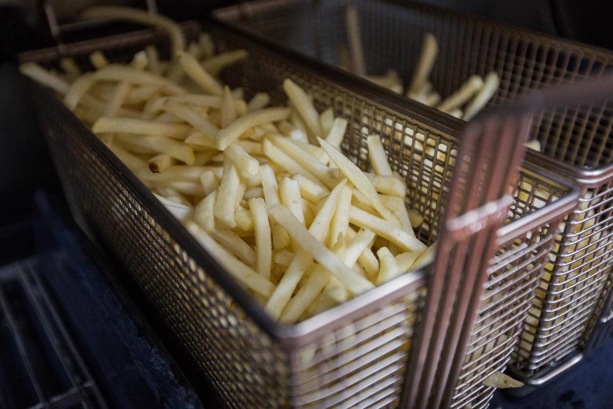 basket of french fries which will be used for fries seen in the kitchen at a McDonald's