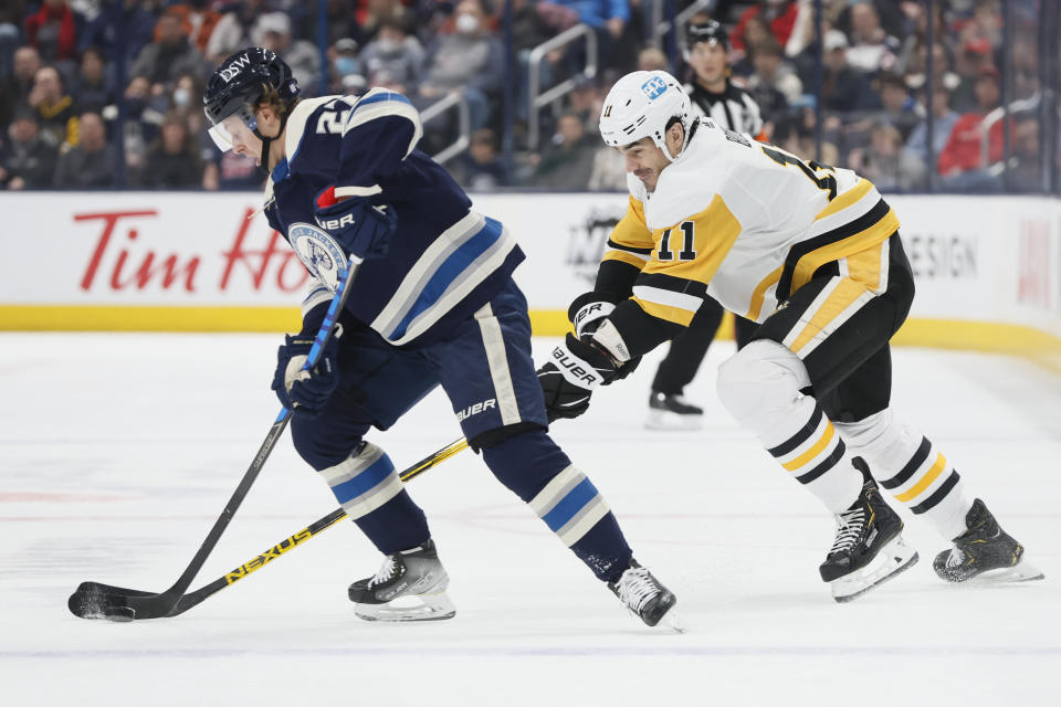 Columbus Blue Jackets' Adam Boqvist, left, tries to keep the puck away from Pittsburgh Penguins' Brian Boyle during the first period of an NHL hockey game Sunday, Feb. 27, 2022, in Columbus, Ohio. (AP Photo/Jay LaPrete)