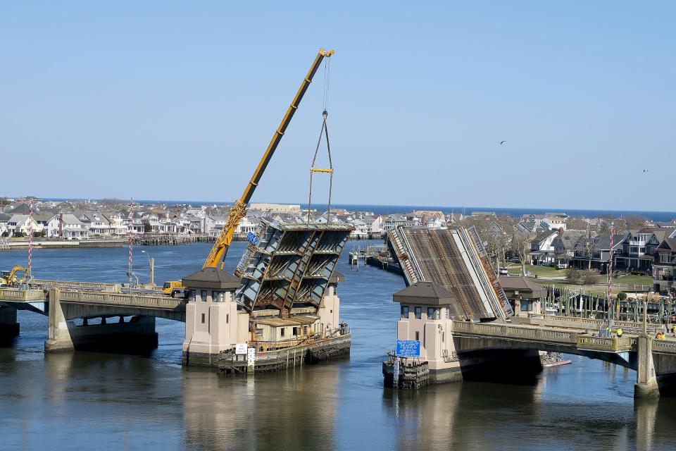 A crane holds the north leaf of the Route 71 bridge over the Shark River, between Belmar (right) and Avon-By-The- Sea, in an open position Tuesday, March 12, 2024. The bridge was stuck in the closed position, blocking boat access to the ocean.