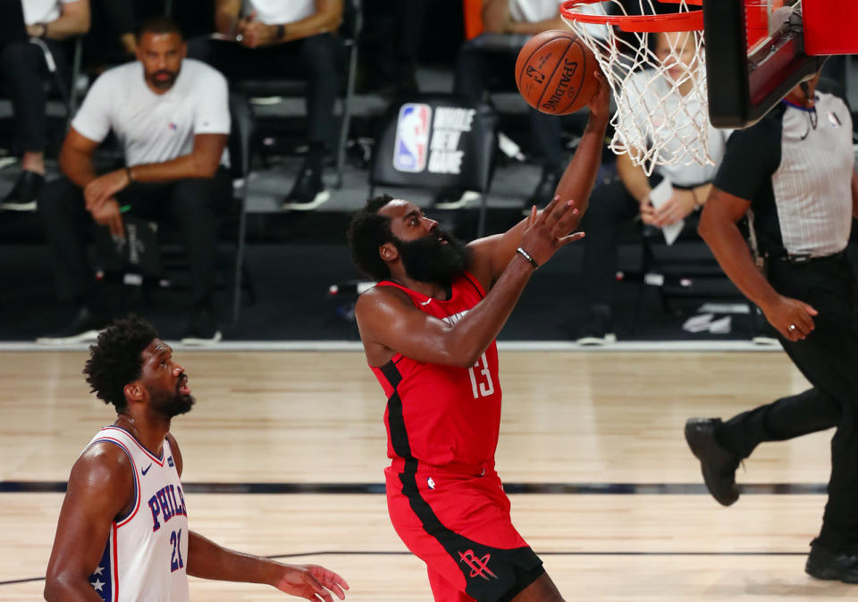 James Harden scores in front of Joel Embiid