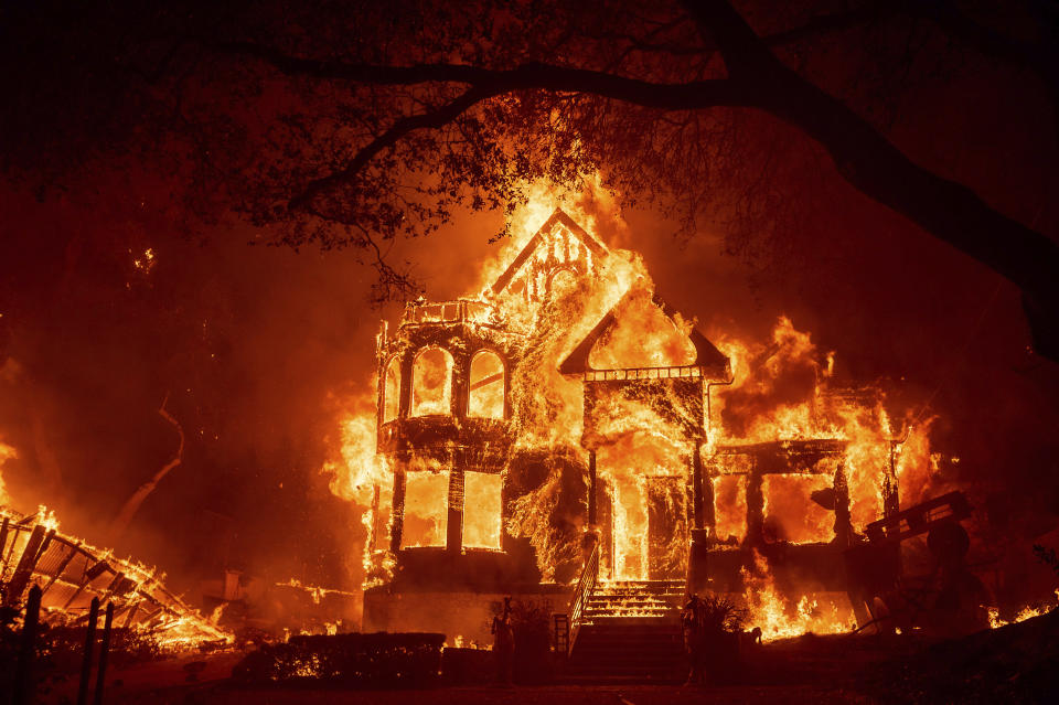 CORRECTS NAME OF INN TO BLACK ROCK INN INSTEAD OF GLASS MOUNTAIN INN - Flames from the Glass Fire consume the Black Rock Inn, late Sunday, Sept. 27, 2020, in St. Helena, Calif. (AP Photo/Noah Berger)