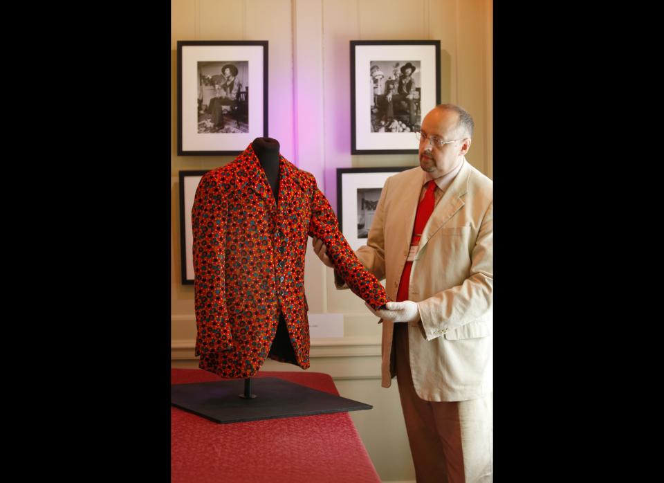 Deputy Director of the museum, Martin Wyatt poses with a Jimi Hendrix's orange velvet jacket in preparation for display in an exhibition 'Hendrix in Britain'.  Hendrix bought the jacket in 1967 from the British designer Dandie Fashions and wore it during his performance in Dec. 1967 at City Hall in Newcastle upon Tyne, England.     AP Photo/Sang Tan