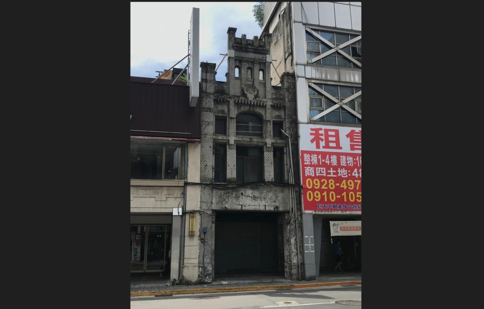 台北市衡陽路92號店屋建於百年前日治時期，外觀雖已老舊破損，仍可從屋頂牌樓及中間商號標誌瞥見過往風華，具高度歷史價值及稀少性，在27日被指定為市定古蹟。（圖／台北市文化局提供）