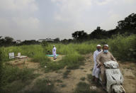 An Indian Muslim man looks for the grave of his relative who died of coronavirus in New Delhi, India, Wednesday, Sept. 16, 2020. India is now second in the world with the number of reported coronavirus infections with over 5.1 million cases, behind only the United States. Its death toll of only 83,000 in a country of 1.3 billion people, however, is raising questions about the way it counts fatalities from COVID-19. (AP Photo/Manish Swarup)