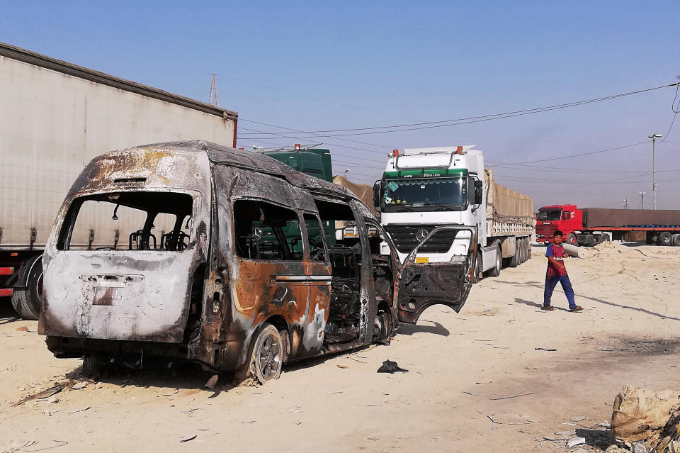 A destroyed minibus sits near an Iraqi army checkpoint about 10 kms. (6 miles) south of Karbala, Iraq, Saturday, Sept. 21, 2019. A bomb exploded on a minibus packed with passengers outside the Shiite holy city of Karbala Friday night, killing and wounding civilians, Iraqi security officials said. (AP Photo/Hadi Mizban)