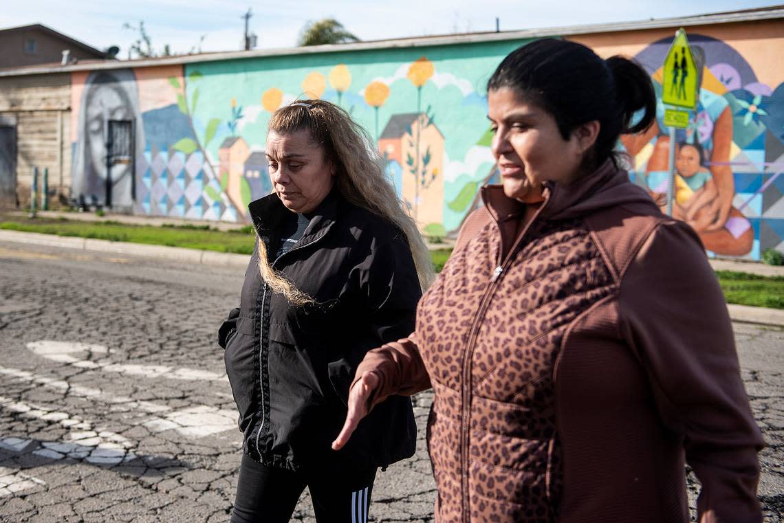 Alicia Rodriguez, president of St. Vincent De Paul Planada Sacred Heart Conference, right, speaks with Gloria Canal, left, as they walk to the home of Canal’s father in Planada, Calif., on Thursday, Jan. 12, 2023. Canal helped her father evacuate from the town after flooding forced residents from their homes.