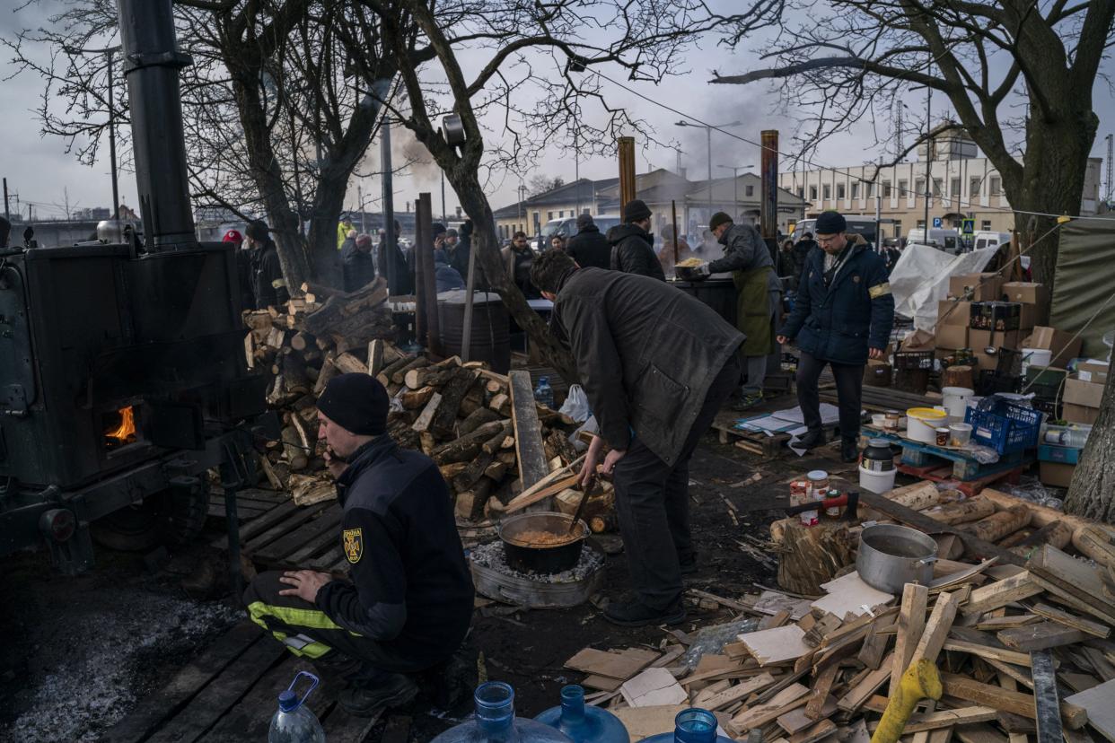 Ukrainian volunteers prepare food for displaced people outside Lviv railway station, in Lviv, western Ukraine, Thursday, March 3, 2022. Russia’s invasion of Ukraine has forced more than a million people to flee their homeland in just a week.