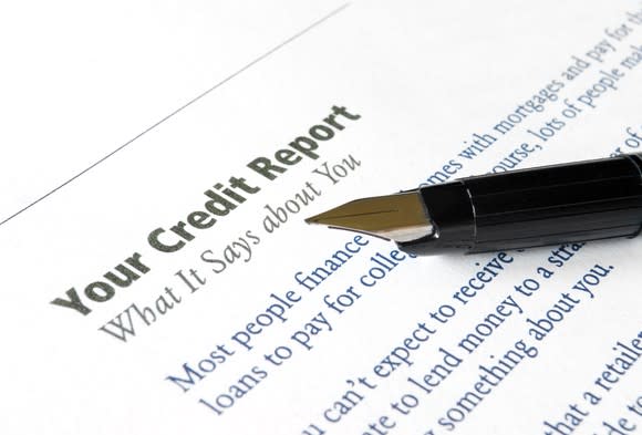 A pen sits on top of a document titled "your credit report: what it says about you."