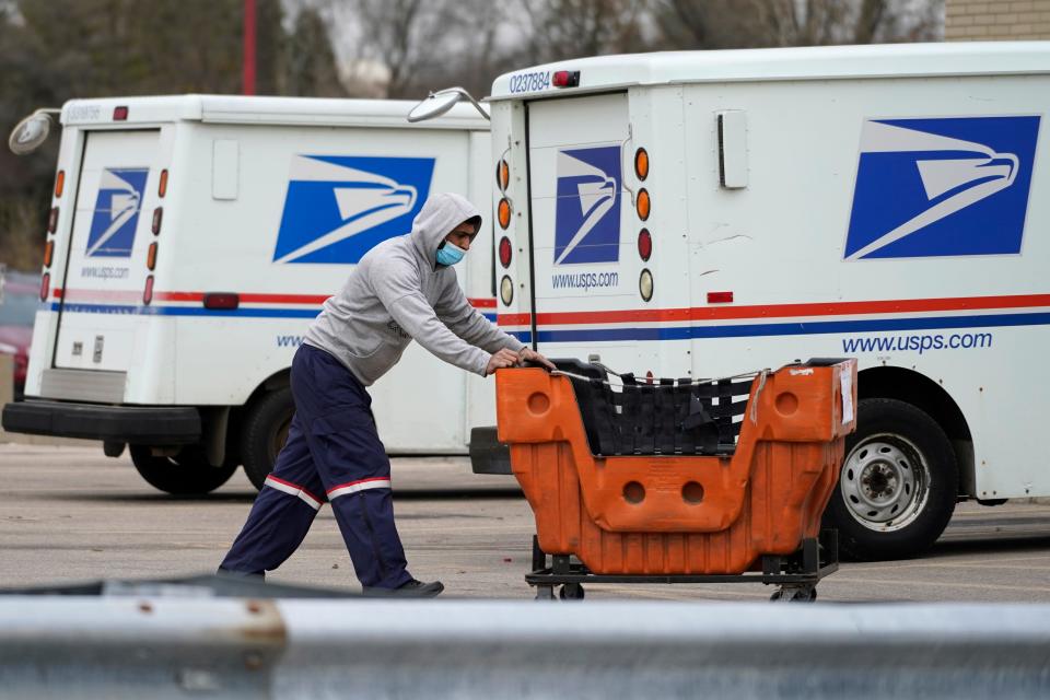 A U.S Postal Service employee works outside a post office in Wheeling, Illinois, Dec. 3, 2021.