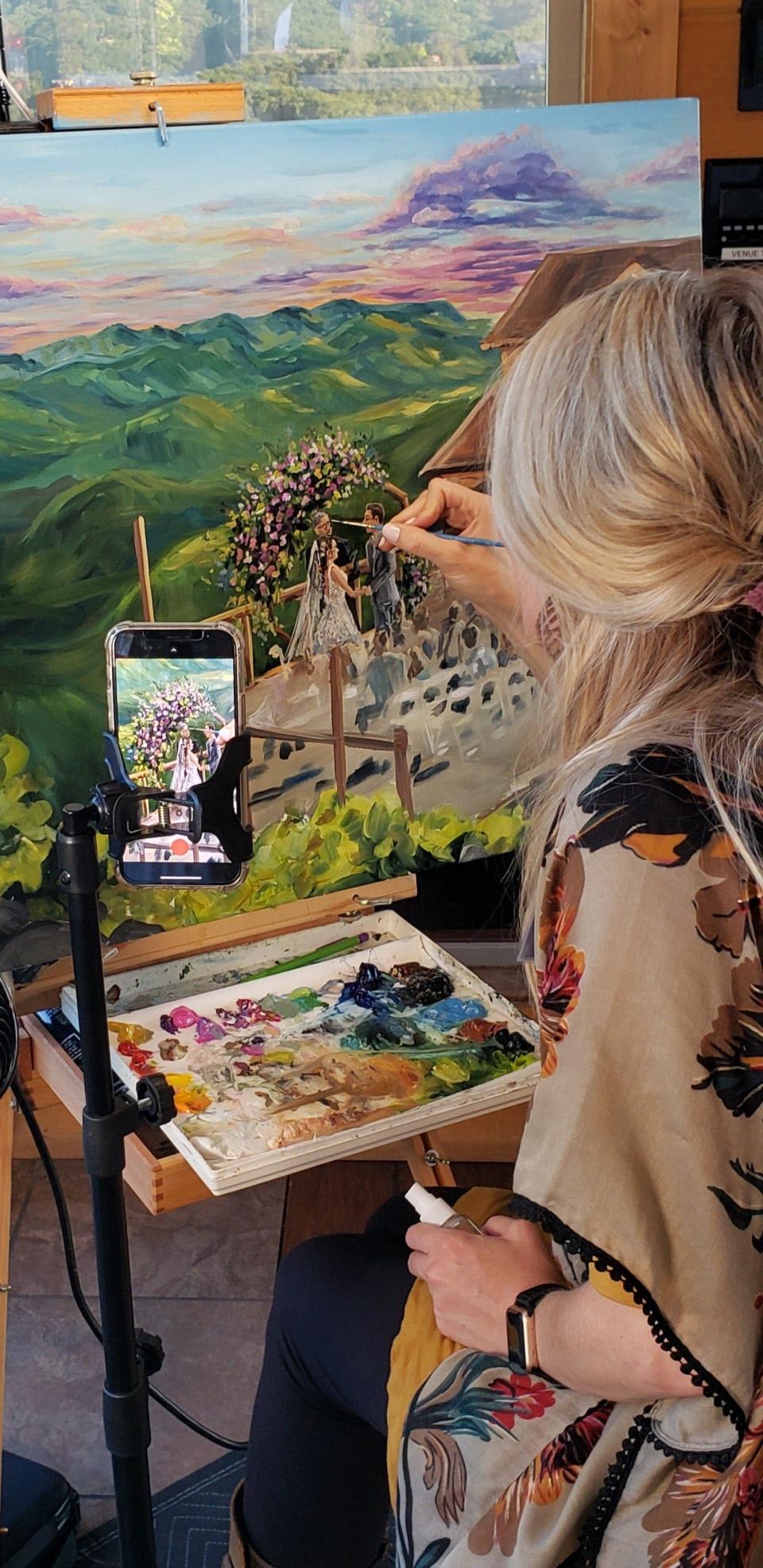 Heather Wolfe puts the final details on a live wedding portrait in her studio on Oct. 6, 2021.