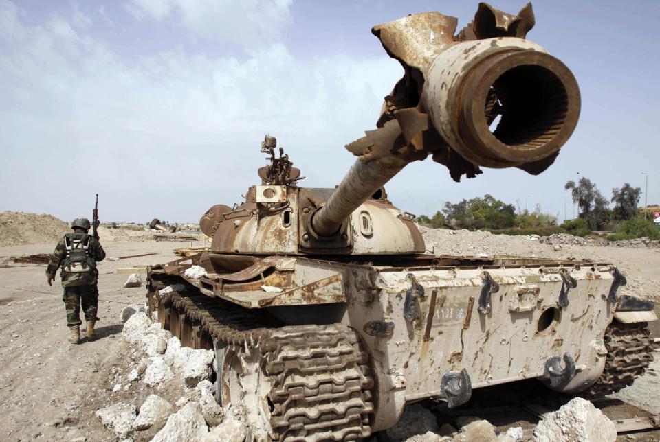 An Iraqi soldier is seen near an Iraqi Army tank, which was destroyed in the U.S.-led invasion, in Basra, Iraq's second-largest city, 340 miles southeast of Baghdad, Iraq on Thursday, April 9, 2009.