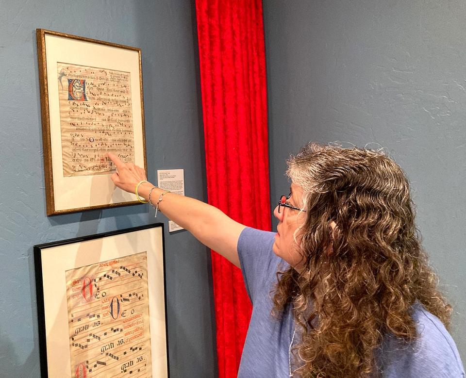 Betty Bynum, a staff member at the Citadelle Art Museum in Canadian, points to a leaf from an antiphonal, or the sung portion of a Catholic Mass, which was created in 1360 in Italy. The leaf is part of the “Painted Pages” exhibit at the Citadelle on display through Nov. 18.