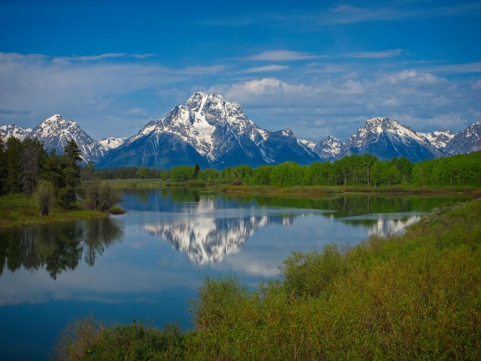 Mt Moran is reflected in the still waters of the Snake River at Oxbow Bend in Grand Teton National Park.