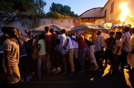 Migrants queue for food at a makeshift camp in Via Cupa (Gloomy Street) in downtown Rome, Italy, August 2, 2016. REUTERS/Max Rossi