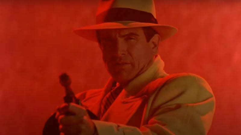 DickTracy, bathed in red light, fires a tommy gun at various criminals.