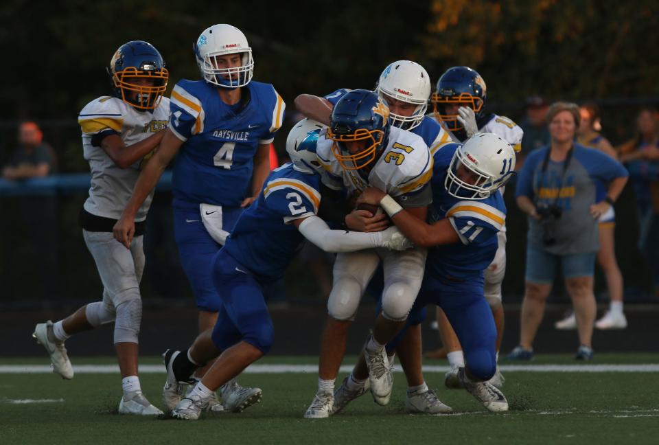 Maysville defenders, including Wesley Armstead (2) and Nate Harper (11) swarm West Muskingum's Ty Shawger.