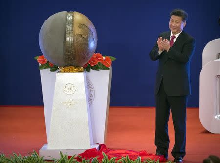 Chinese President Xi Jinping applauds after unveiling a sculpture during the opening ceremony of the Asian Infrastructure Investment Bank (AIIB) in Beijing, China, January 16, 2016. REUTERS/Mark Schiefelbein/Pool