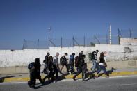 A travel agency employee (R) escorts refugees and migrants to buses heading to the borders of Greece with Macedonia, following their arrival on the Blue Star Patmos passenger ship at the port of Piraeus, near Athens, Greece, October 6, 2015. REUTERS/Alkis Konstantinidis