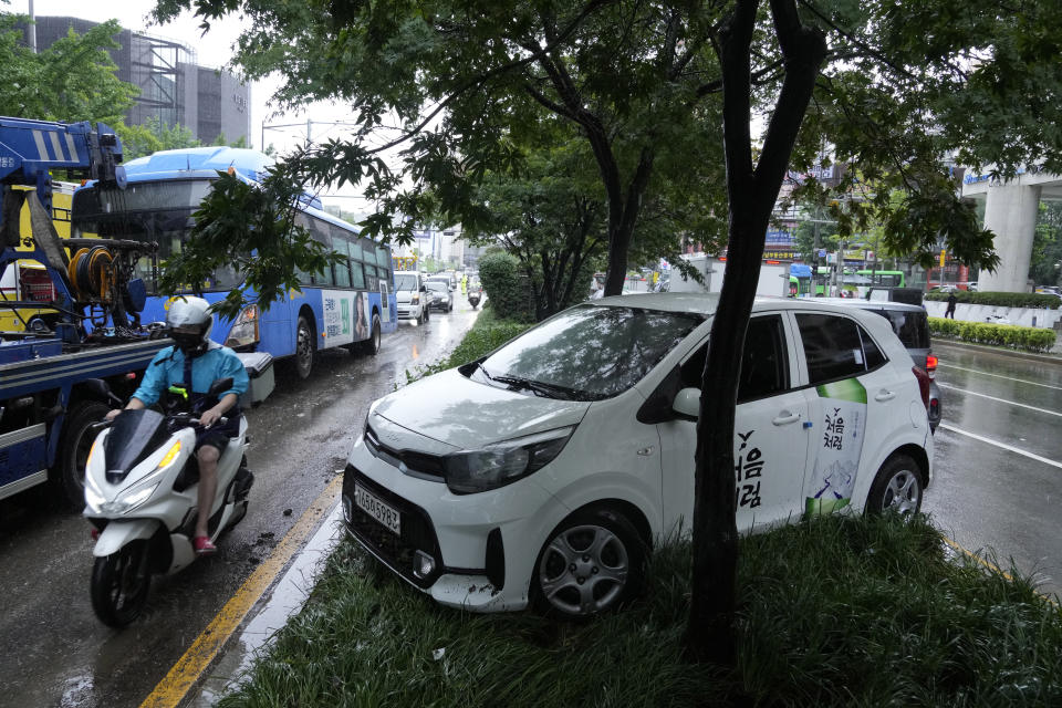 A vehicle sits damaged on a road divider after floating in heavy rainfall in Seoul, South Korea, Tuesday, Aug. 9, 2022. Heavy rains drenched South Korea's capital region, turning the streets of Seoul's affluent Gangnam district into a river, leaving submerged vehicles and overwhelming public transport systems. (AP Photo/Ahn Young-joon)