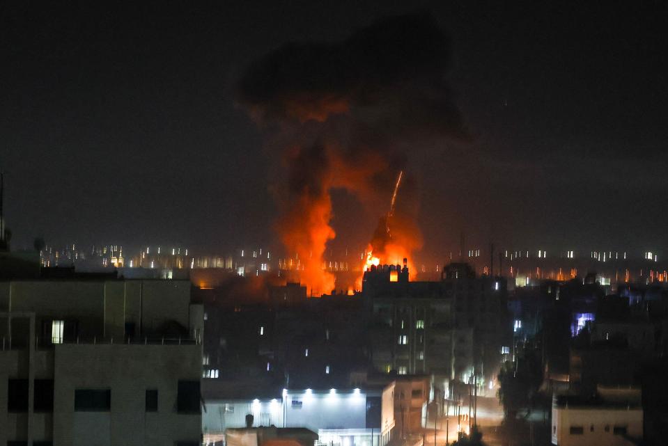 Explosions light-up the night sky above buildings in Gaza City (AFP via Getty Images)