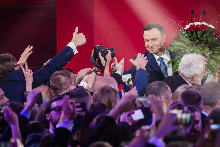 Andrzej Duda (R), presidential candidate of the right-wing opposition party Law and Justice (PiS), celebrates after exit poll results are announced in Warsaw, on May 24, 2015