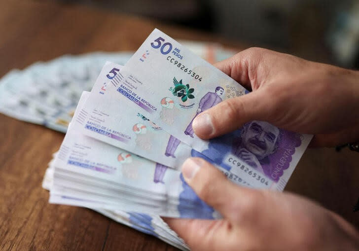 Un empleado cuenta billetes de pesos colombianos en una casa de cambios, en Bogotá, Colombia