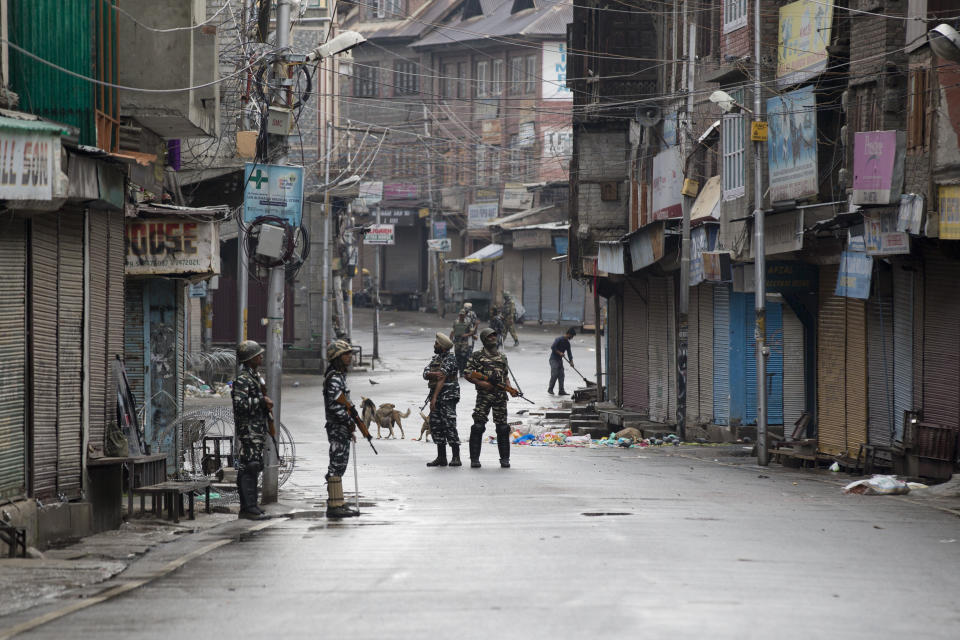 Indian Paramilitary soldiers stand guard on a deserted street during curfew in Srinagar, Indian controlled Kashmir, Thursday, Aug. 8, 2019. The lives of millions in India's only Muslim-majority region have been upended since the latest, and most serious, crackdown followed a decision by New Delhi to revoke the special status of Jammu and Kashmir and downgrade the Himalayan region from statehood to a territory. Kashmir is claimed in full by both India and Pakistan, and rebels have been fighting Indian rule in the portion it administers for decades. (AP Photo/Dar Yasin)