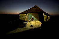 <p>A Syrian refugee woman tends to her daughter while cooking inside her tent at an informal tented settlement near the Syrian border on the outskirts of Mafraq, Jordan, Aug. 26, 2015. (Photo: Muhammed Muheisen/AP) </p>