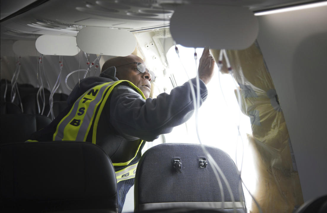 In this photo released by the National Transportation Safety Board, John Lovell, NTSB investigator in charge, inspects the fuselage connection area of ​​Alaska Airlines Flight 1282 on Sunday, Jan. 7, 2024, in Portland, Oregon.  A panel used to seal off the area of ​​a Boeing 737 MAX 9 exit door exploded Friday night shortly after the flight took off from Portland, forcing the plane to return to Portland International Airport.  (National Transportation Safety Board via AP)