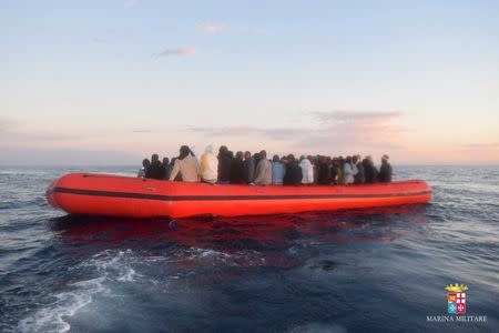 Migrants sit in their boat during a rescue operation of 219 migrants by Italian naval vessel Bettica (not seen) in this February 23, 2016 handout picture provided by Marina Militare. REUTERS/Marina Militare/Handout via Reuters