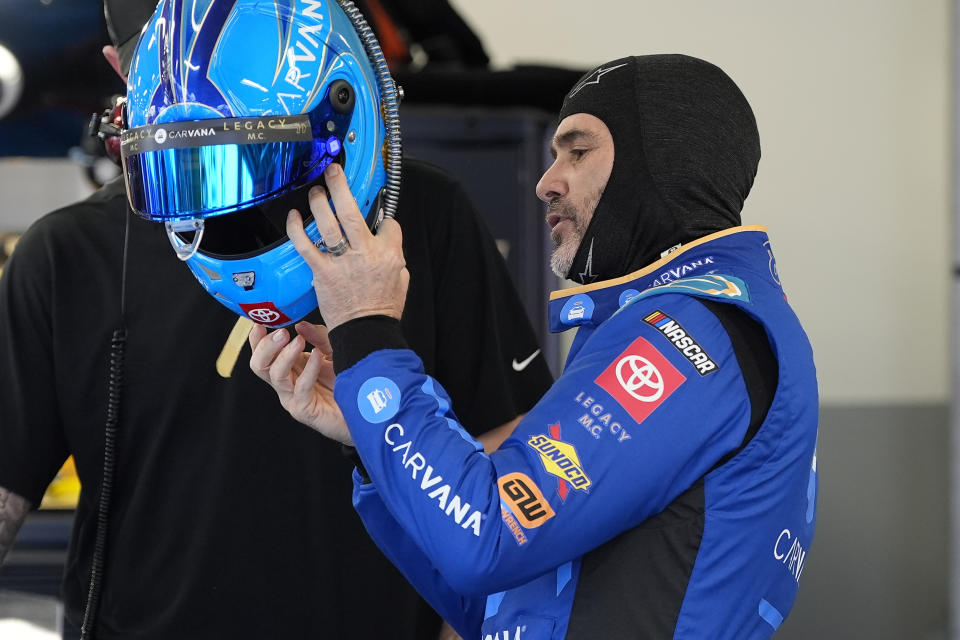 Jimmie Johnson prepares to put on his helmet during a practice session for the NASCAR Daytona 500 auto race Friday, Feb. 16, 2024, at Daytona International Speedway in Daytona Beach, Fla. (AP Photo/Chris O'Meara)