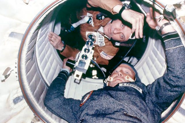 Astronaut Thomas P. Stafford (top) and cosmonaut Aleksei A. Leonov look through a hatchway leading from the Apollo Docking Module to the Soyuz Orbital Module during the first American and Russian joint space mission in 1975. File Photo by NASA
